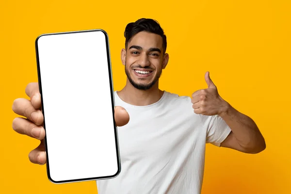 Snygg arabisk kille som visar smartphone med tom skärm — Stockfoto