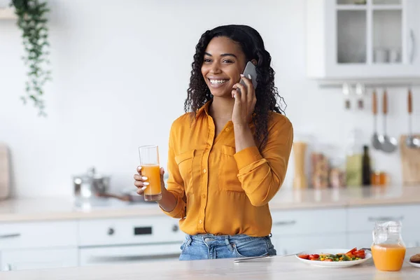 Felice donna di colore che fa colazione e parla al telefono — Foto Stock