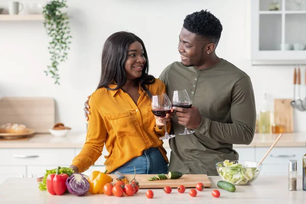 Santé pour nous. Romantique couple noir boire du vin rouge dans la cuisine — Photo