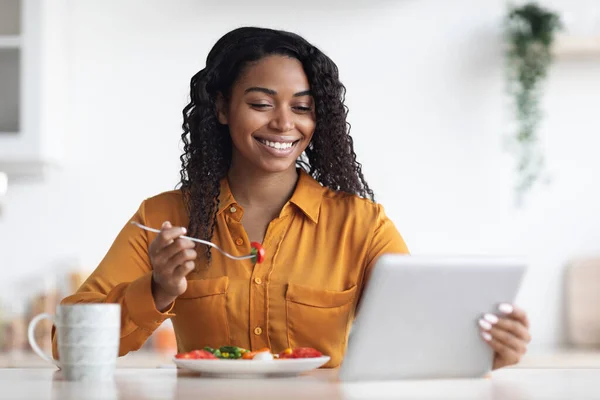 Šťastná černošky žena pomocí digitální tablet při snídani — Stock fotografie