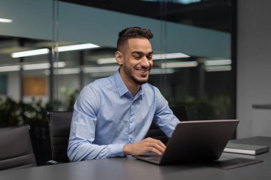 Neşeli Orta Doğulu yönetici deftere yazı yazıyor.