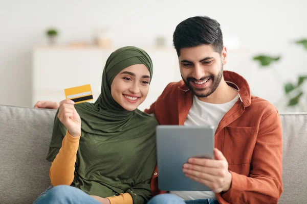 Мусульманська пара робить онлайн покупки через цифровий планшет вдома — стокове фото