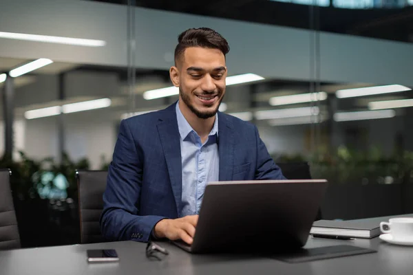 Smiling middle eastern businessman typing on computer at office — Stock Photo, Image