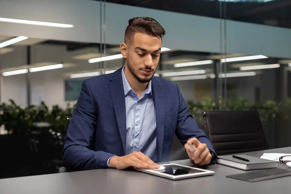Schöner Geschäftsmann aus dem Nahen Osten putzt digitalen Tablet-Bildschirm — Stockfoto