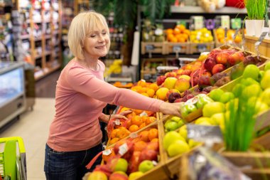 Güzel yaşlı bayan süpermarketten alışveriş yapıyor.