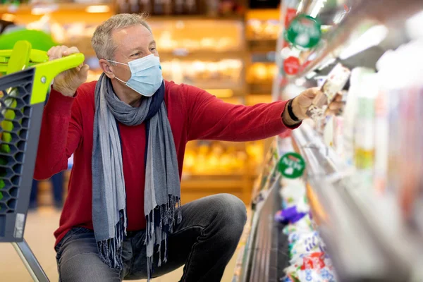 Senior man in face mask customer shopping while coronavirus pandemic