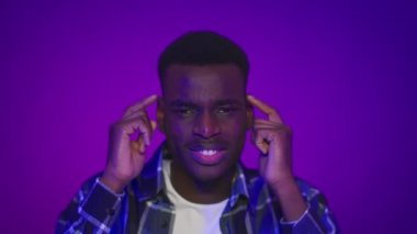 Siyahi adam Mor Arkaplan 'ı parmağıyla işaret ediyor.