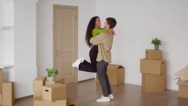 Esposo Spinning Holding esposa en brazos entre cajas de cartón en interiores — Vídeo de stock