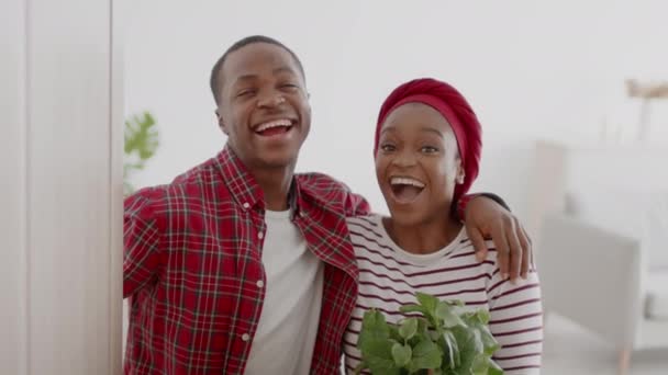 Casal afro-americano alegre abertura porta sorridente abraçando em casa — Vídeo de Stock