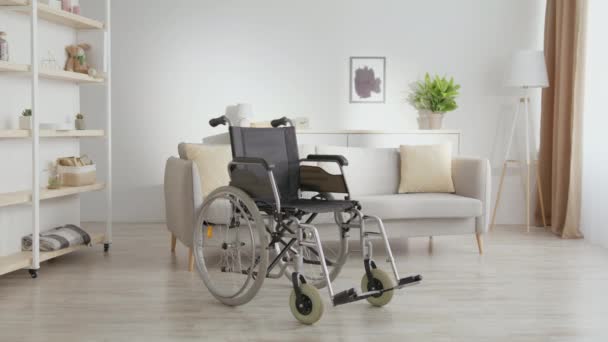Engelli ve sağlık sorunları. Evde duran boş tekerlekli sandalyeyi yakınlaştır. Kazalar ve travmalar kavramı — Stok video