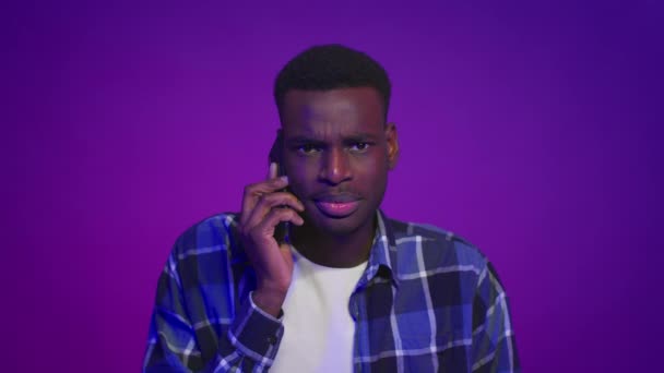 Afro-american tip vorbind pe telefon mobil în picioare peste fundal violet — Videoclip de stoc