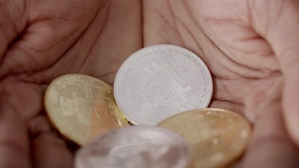 Fechar-se de mãos masculinas segurando prata e Bitcoins dourados interior — Vídeo de Stock