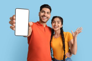 Mobil Model. Kamerada Büyük Boş Akıllı Telefon Gösteren Olumlu Genç Arap Çift