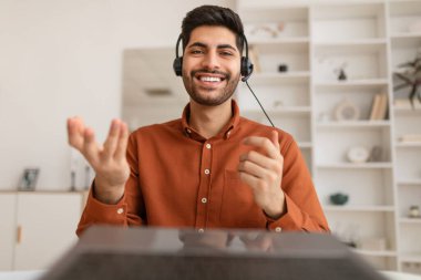 Masada oturan ve kulaklık takan bir Arap.