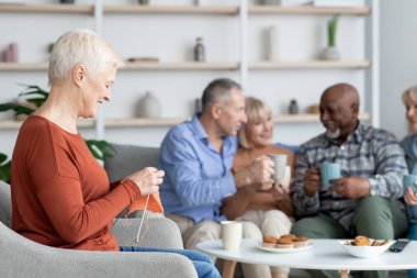 Neşeli çok ırklı yaşlılar huzurevinde birlikte vakit geçiriyorlar.