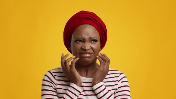 Nervös svart kvinna oroande känsla rädsla över gul studio bakgrund — Stockvideo