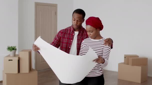 Los cónyuges negros planifican la renovación en un nuevo plan de papel para el hogar — Vídeo de stock