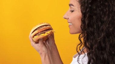 Stüdyoda sandviç gösteren komik bir kadın.