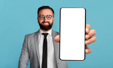 Mobil teklif. Boş ekran ile cep telefonu tutan yakışıklı işadamı, model aygıtı gösteriyor