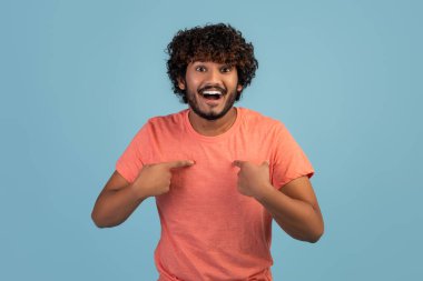 Şaşırmış Hintli adam kendini işaret ediyor, mavi arka plan.