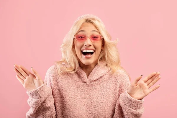 Positive emotions. Excited stylish lady screaming with joy and spreading hands, posing over pink studio background — Stock Photo, Image