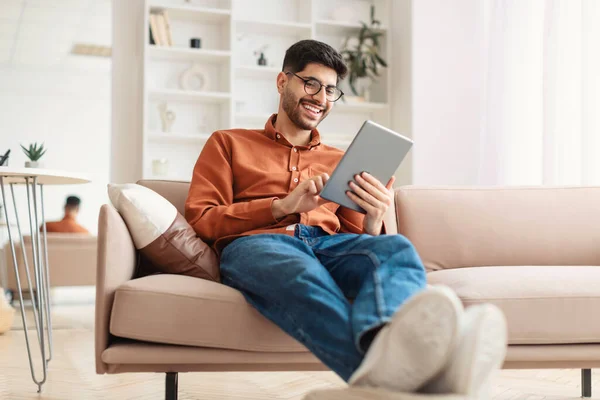 Sorrindo jovem árabe usando tablet digital em casa — Fotografia de Stock