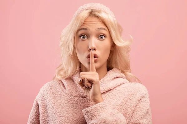 Shh, maradj csendben. fiatal nő bemutató titokzatos gesztus, gesztikuláló csend rózsaszín stúdió háttér — Stock Fotó