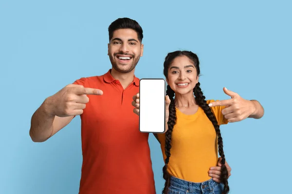 Alegre animado Médio Oriente casal apontando em branco Smartphone tela para Mockup — Fotografia de Stock
