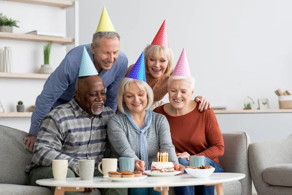 Счастливой многорасовой группы пенсионеров, празднующих день рождения вместе — стоковое фото