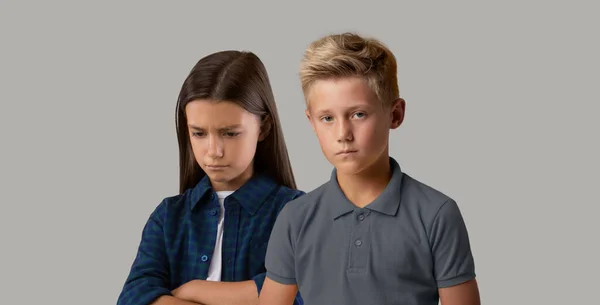 Concepto de emociones negativas. Retrato de niños preadolescentes trastornados posando sobre fondo gris —  Fotos de Stock