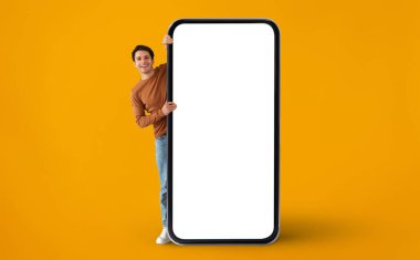 Yakışıklı Genç Adam, Büyük Boş Akıllı Telefonun Arkasından Bakıyor