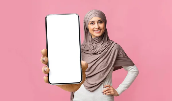 Glückliche junge muslimische Dame im Hijab zeigt Handy mit leerem Bildschirm, Vorführgerät mit Attrappe — Stockfoto