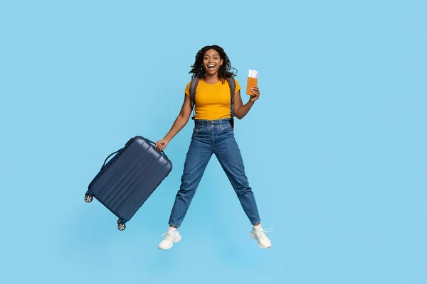 Glückliche Afroamerikanerin mit Koffer und Flugtickets — Stockfoto