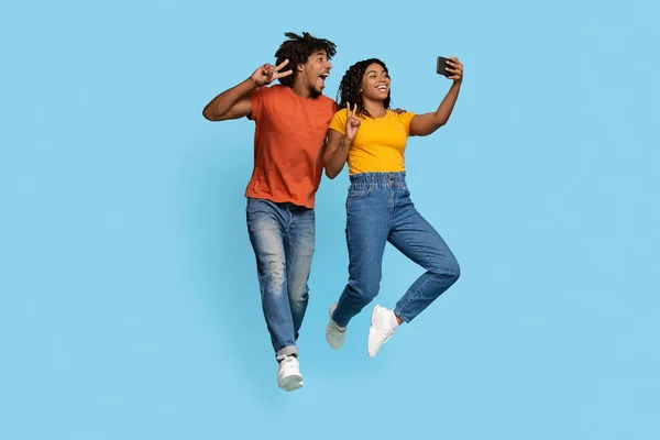 Glückliche afrikanisch-amerikanische Liebespaare beim gemeinsamen Selfie auf blau — Stockfoto