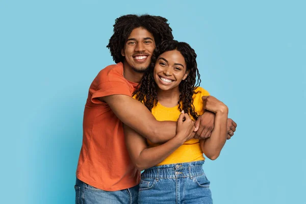 Amoroso hombre negro y mujer abrazándose sobre fondo azul — Foto de Stock