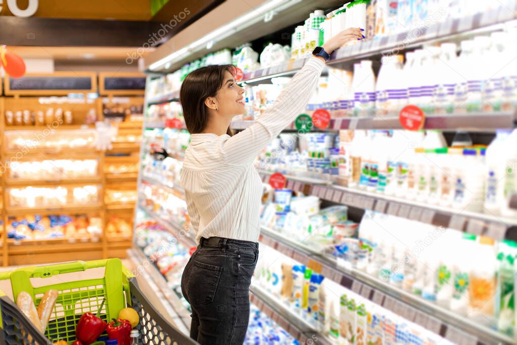 Middle Eastern Female Taking Dairy Product Shopping Groceries In Supermarket