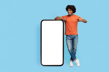 Gülümseyen siyah adam cep telefonunu boş ekranla gösteriyor.