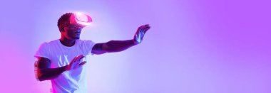 Heyecanlı genç Afrikalı Amerikalı adam VR gözlük kullanıyor.