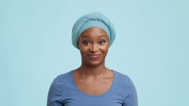 Brincalhão afro-americano fêmea levantando sobrancelhas posando sobre fundo azul — Vídeo de Stock