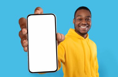 Cep telefonu reklamı. Neşeli Siyah Adam Beyaz Ekranlı Büyük Boş Akıllı Telefonu Gösteriyor