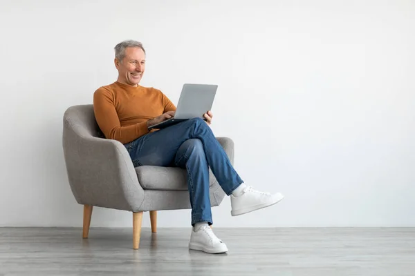 Magabiztos mosolygós érett férfi használja laptop otthon — Stock Fotó