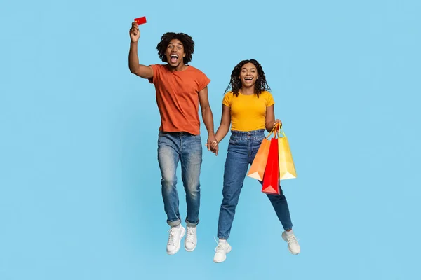 Šťastní afroameričtí milovníci s nákupními taškami a kreditní kartou — Stock fotografie