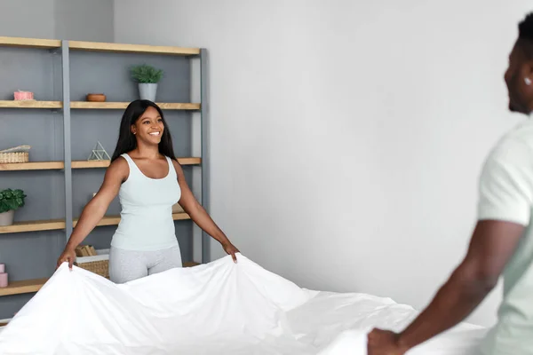 Glad ung afrikansk amerikan par bädda säng med filt efter vakna på morgonen — Stockfoto