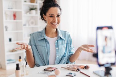 Blog yazarı kadın içeride akıllı telefon aracılığıyla güzellik bloğu için video hazırlıyor