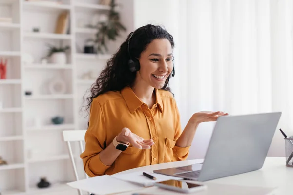 Weibchen führen Videoanrufe mit Headset, das mit Laptop im Haus spricht — Stockfoto