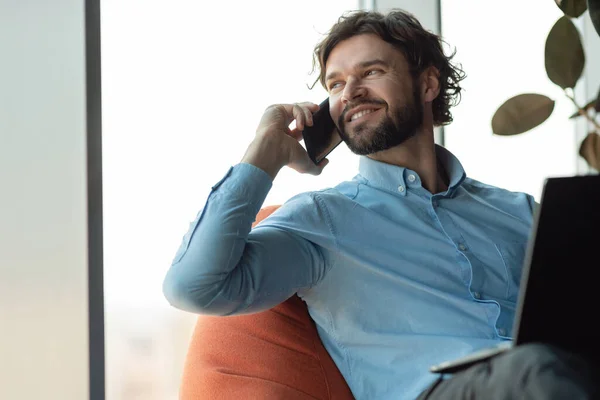 Leende man som jobbar och pratar i telefon på kontoret — Stockfoto