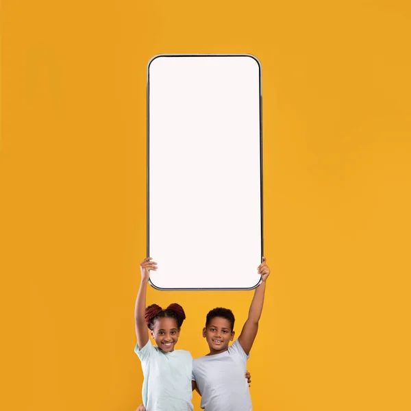 Kleine Schulkinder zeigen weißen leeren Smartphone-Bildschirm — Stockfoto