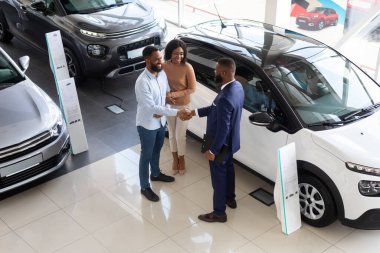 Black Salesman, Satış Merkezindeki Müşteri Çifti ile Tokalaşıyor.