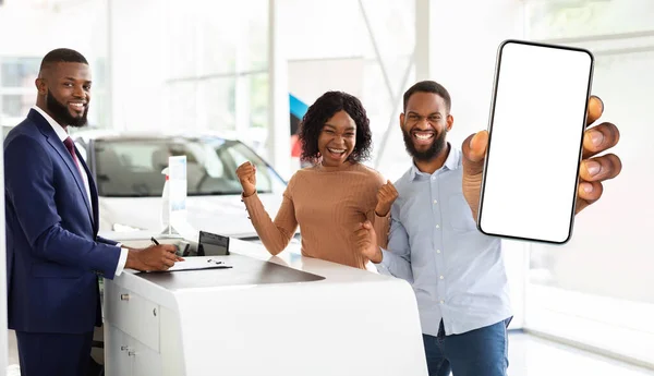 Autóbiztosítás. Fekete házastársak áll Auto bemutatóterem és mutatja üres okostelefon — Stock Fotó