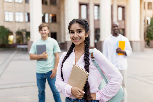 Future professionals. Portrait of multiracial university students posing near university building, focus on girl